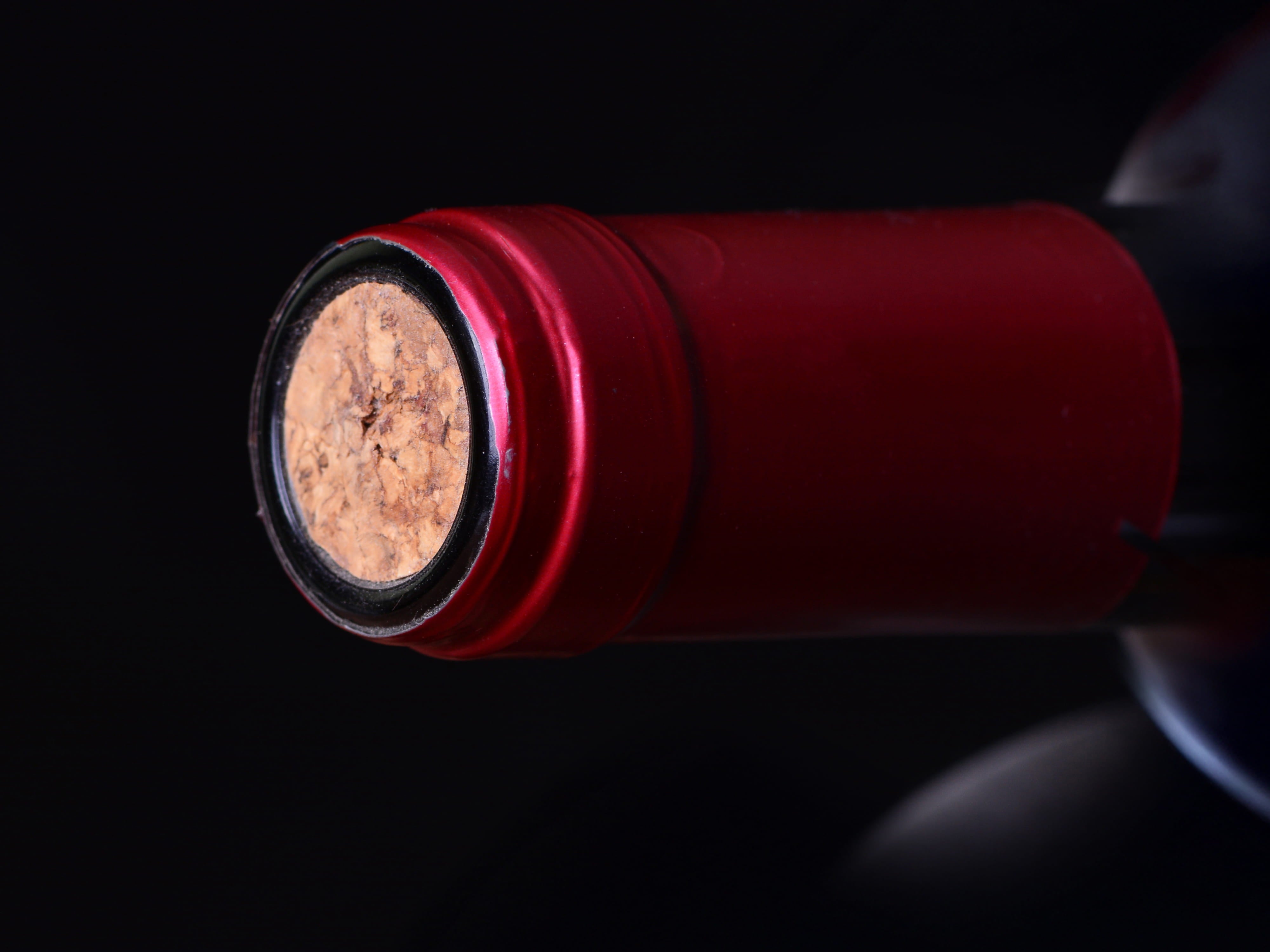 Close-up of a sealed wine bottle cork with red foil capsule